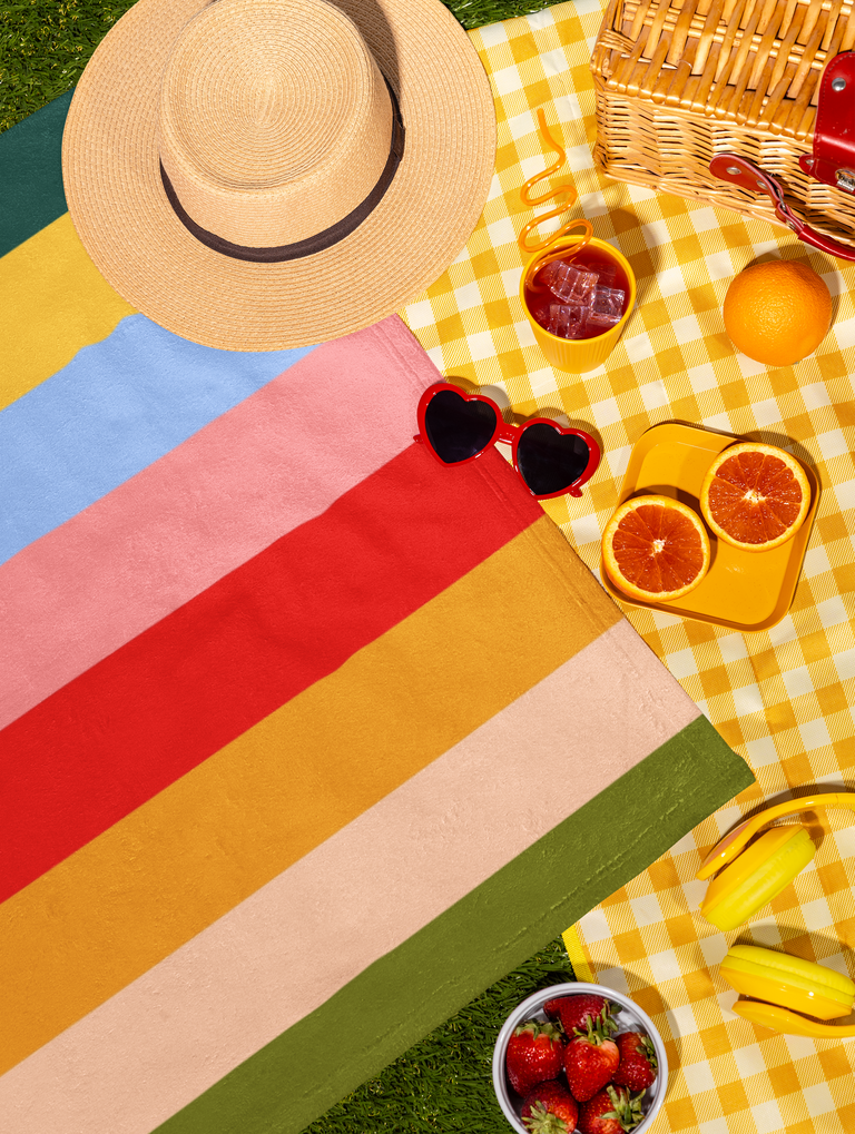 Bold retro stripe beach towel Bold retro stripe towel with summer hat and sunglasses on grass